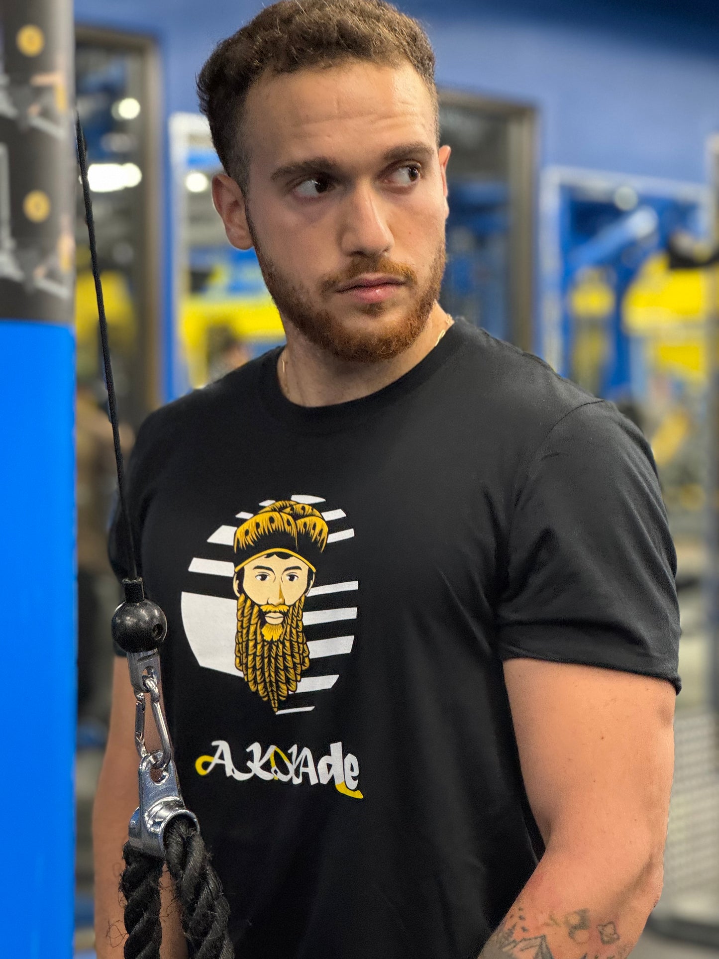 Man wearing a black t-shirt with a graphic design in a gym setting